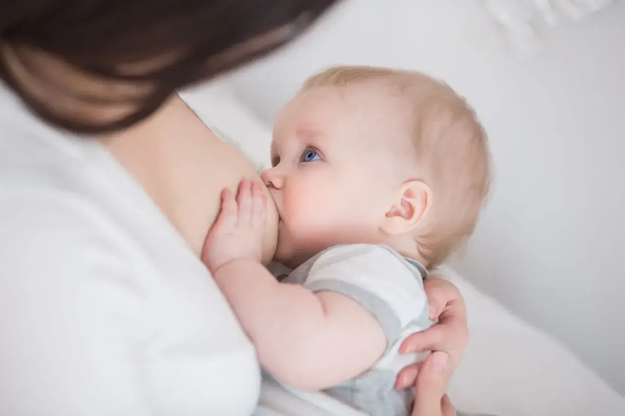 Niemowlę z niebieskimi oczami karmione piersią. Czas trwania nawalu laktacyjnego jest indywidualny.