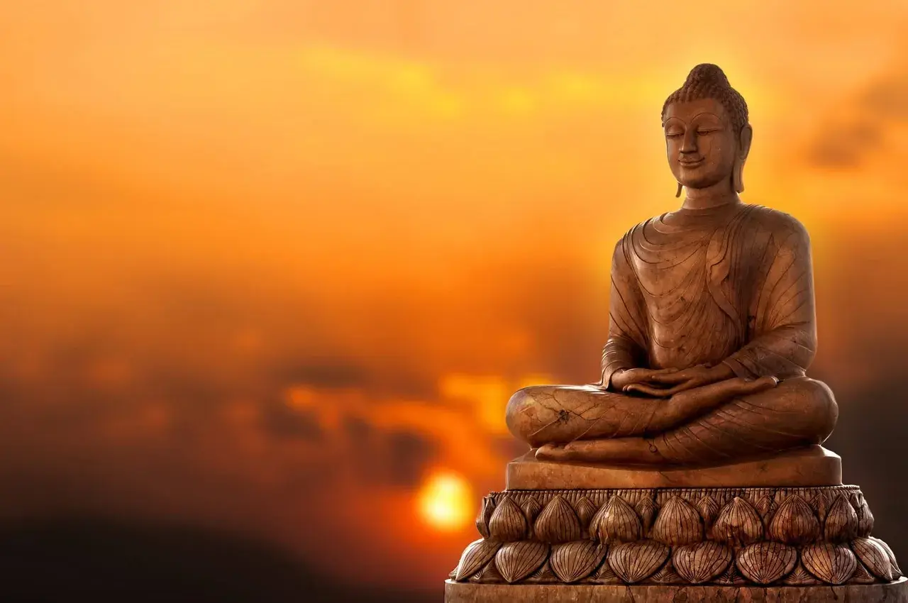 Buddha-staty i solnedgången. Lär dig fakta om buddhismen och dess symbolik.