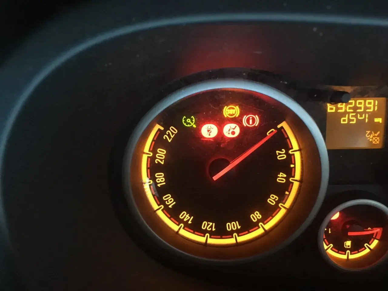 Tableau de bord allumé, voyant ceinture de sécurité rouge, ABS et information activés. Le compteur affiche 69299 km.