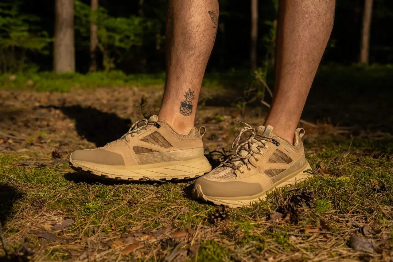 Beżowe buty trekkingowe z siateczkowaną cholewką buta, idealne na leśne wędrówki.