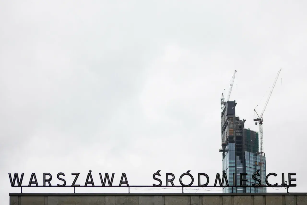 Varso Tower w budowie z dźwigami, na tle napisu "WARSZAWA ŚRÓDMIEŚCIE".
