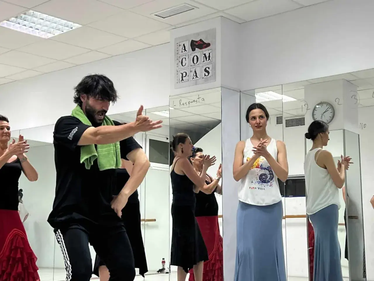 Clase de sevillanas rápidas con un instructor masculino y varias mujeres practicando.