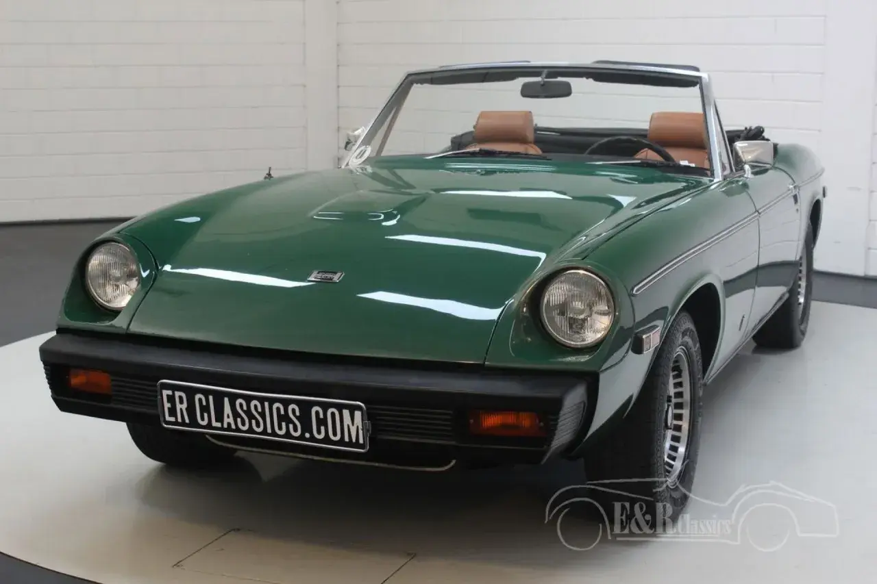 Grön Jensen Healey cabriolet med bruna säten. En klassisk sportbil redo för en solig dag.