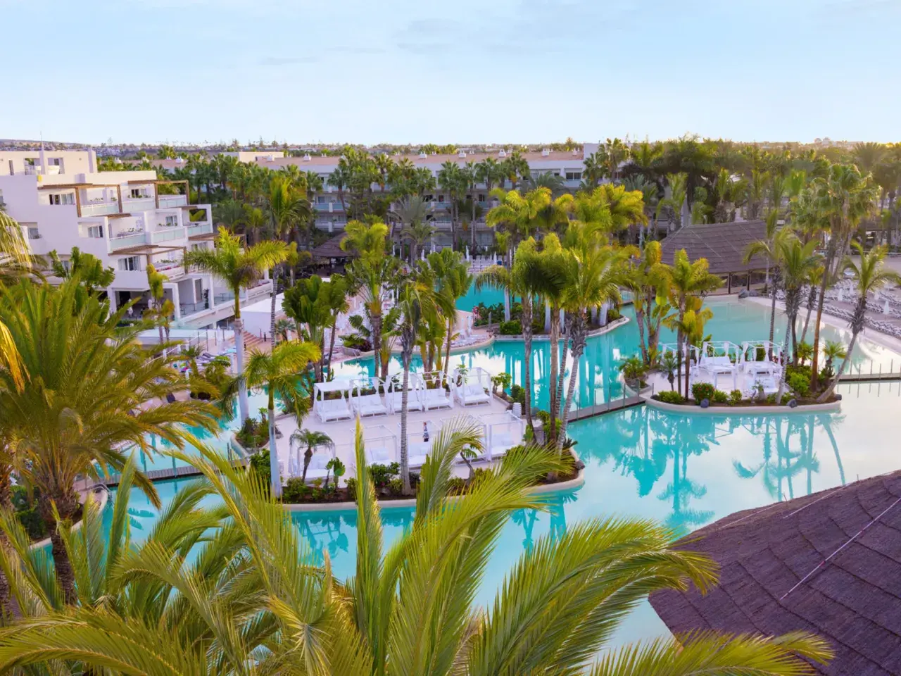 Traumhafter Poolbereich im TUI Kids Club Maspalomas Princess mit Palmen und Liegen.