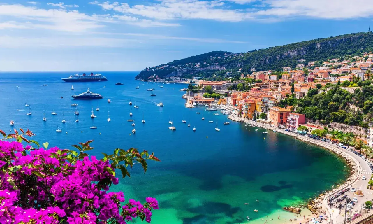 Bunte Küstenstadt mit Yachten im azurblauen Meer. Ein perfektes Bild für die besten Reiseziele im September weltweit.