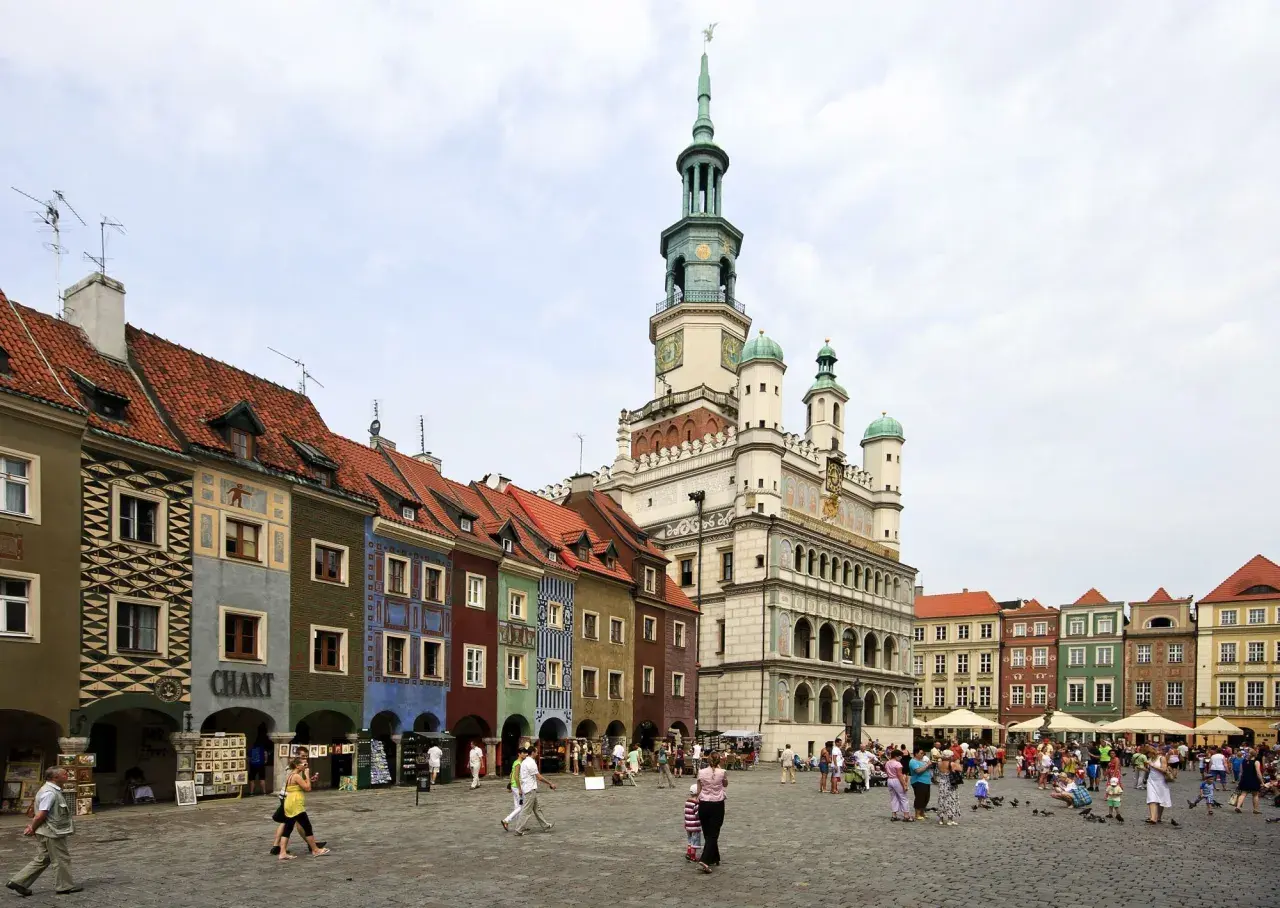 Kolorowy Rynek w Poznaniu, jedno z miejsc, które pokazują, jakie miasta warto zwiedzić w Polsce. Tętniący życiem plac z ratuszem i kamieniczkami.