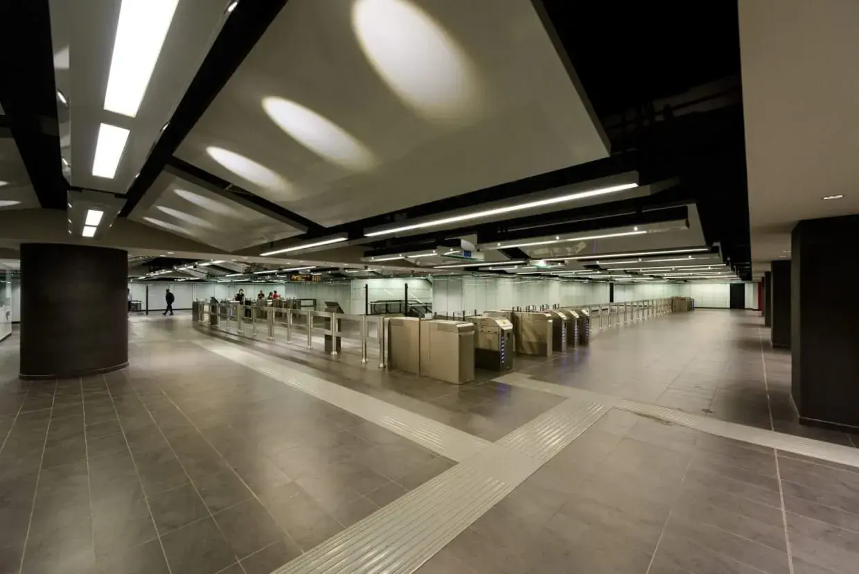 Ingresso moderno della metro Mirti con tornelli e illuminazione a soffitto.