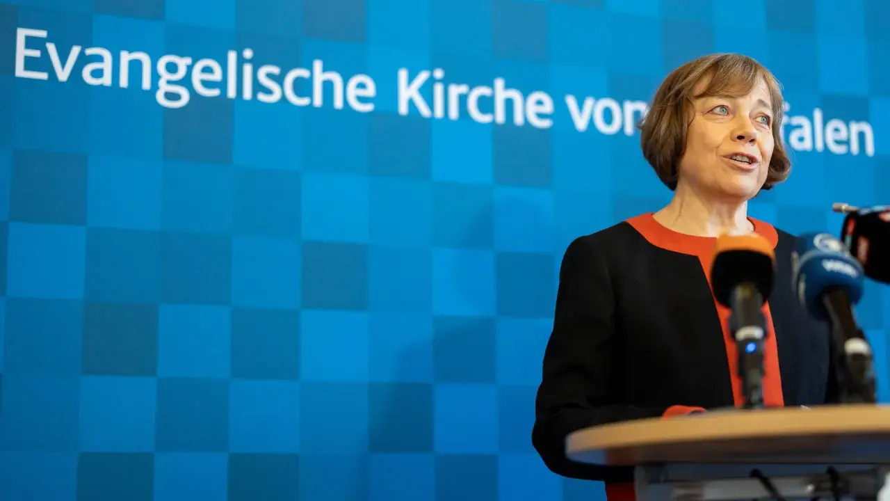 Die EKD-Vorsitzende spricht vor Mikrofonen. Im Hintergrund ist das Logo der Evangelischen Kirche von Westfalen zu sehen.