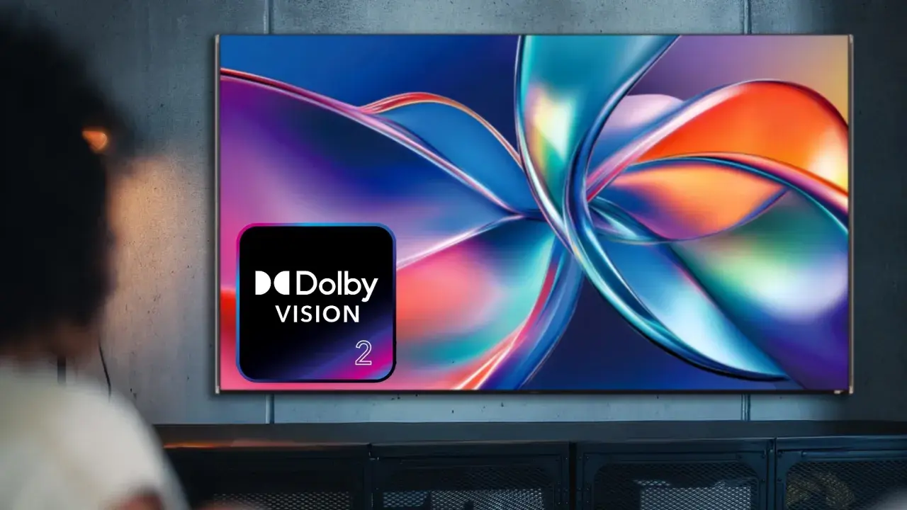 Osoba ogląda telewizor z logo Dolby Vision, wyświetlający abstrakcyjny, kolorowy obraz.