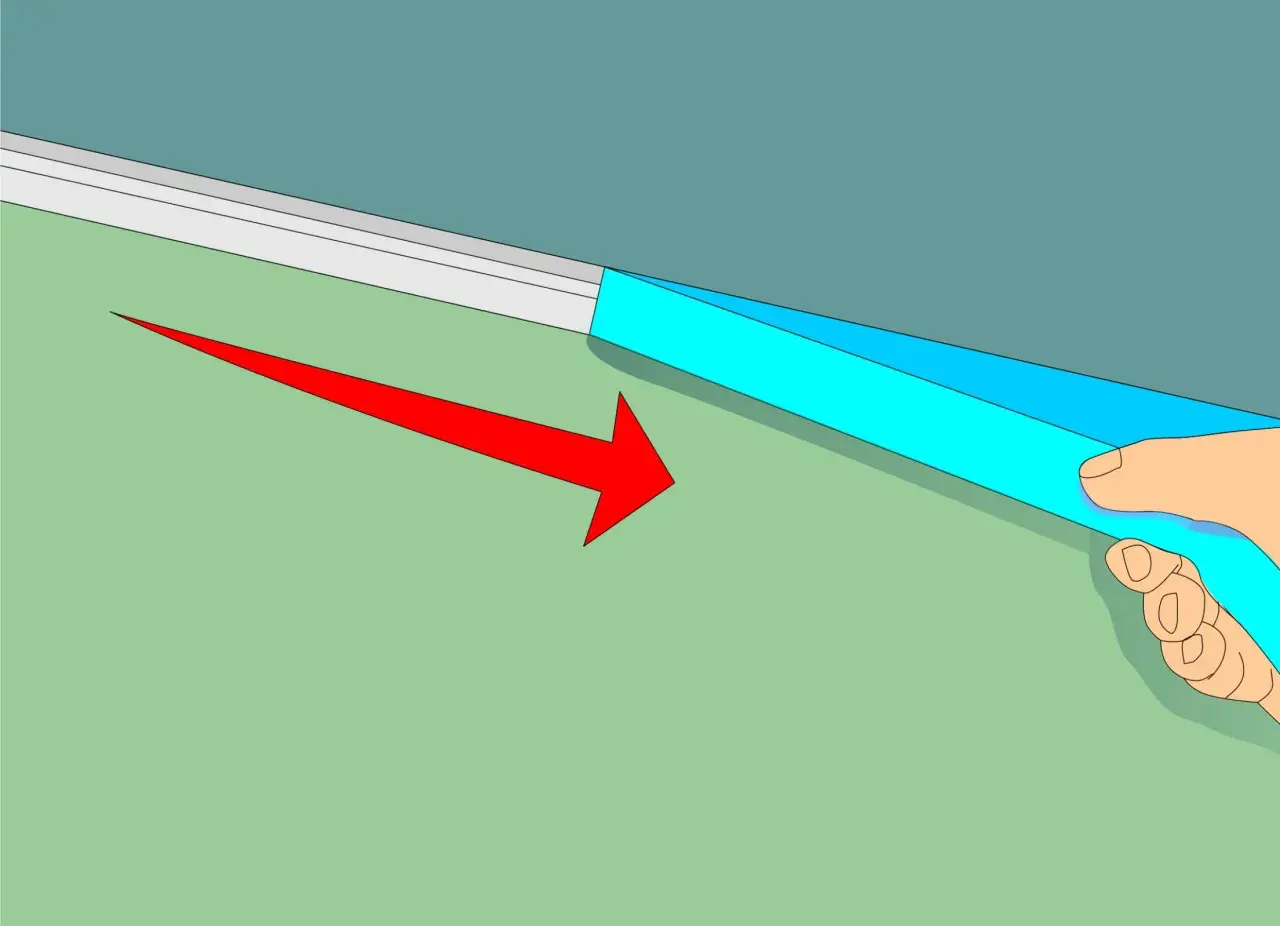 Applicazione di nastro adesivo blu per definire come fare bordo tra soffitto e parete. Freccia rossa indica la direzione.