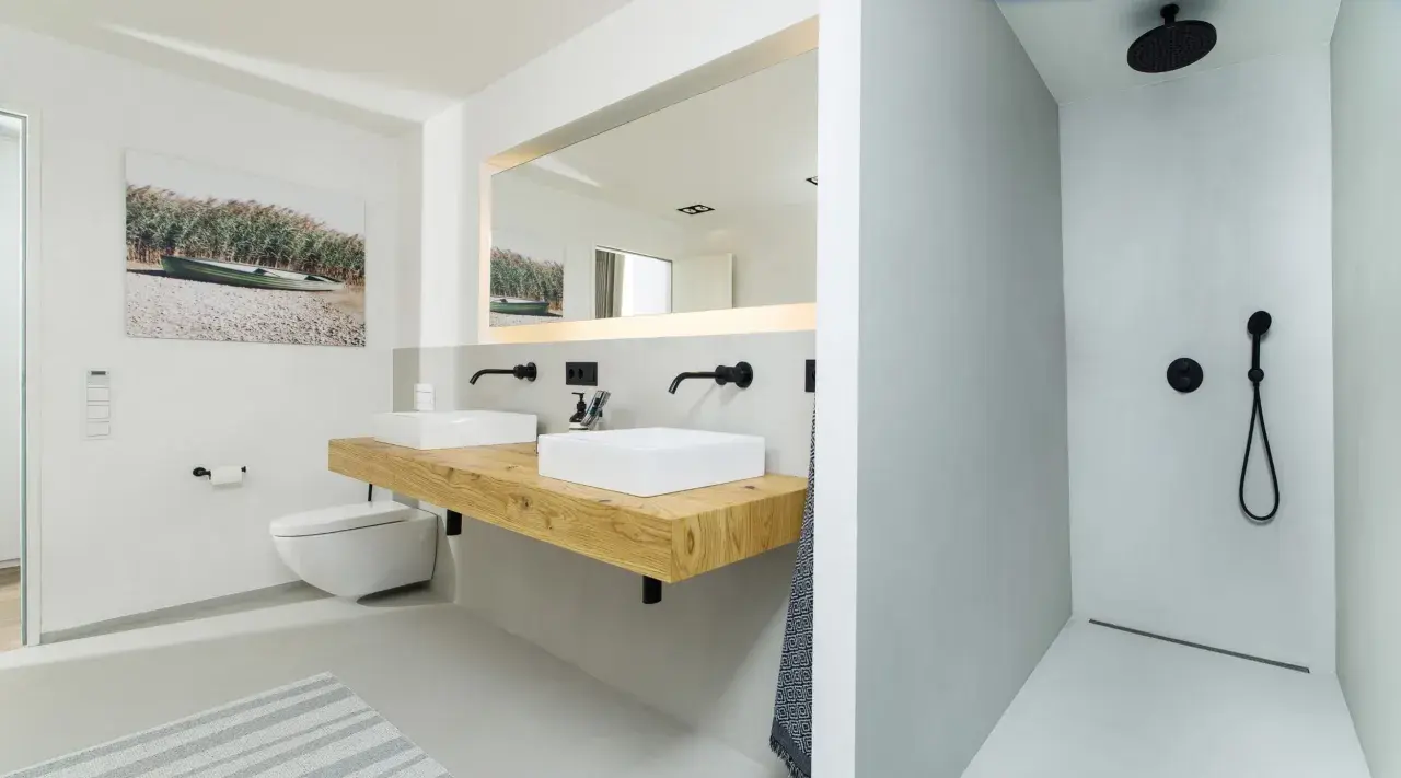Modernes **Bad ohne Fliesen** mit Doppelwaschtisch auf Holzkonsole, wandhängendem WC und ebenerdiger Dusche.