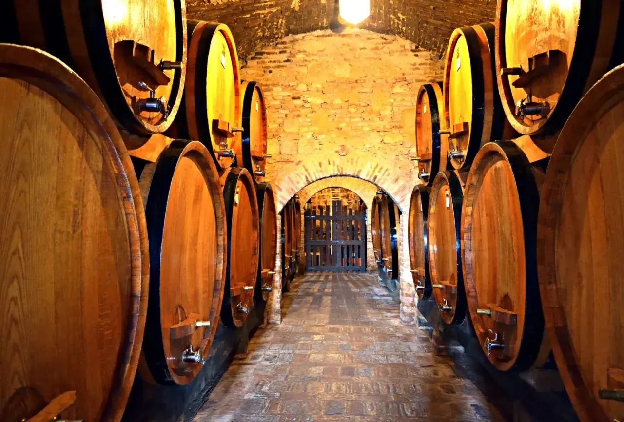 Corridoio di cantine in Toscana, con botti di legno che maturano il vino.