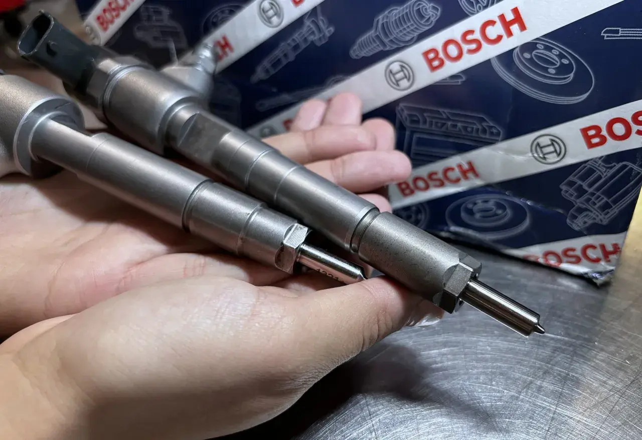 Dwie wtryskiwacze Bosch w dłoni, gotowe do montażu. Ich precyzja zapewnia samoadaptację wtryskiwaczy dla optymalnej pracy silnika.