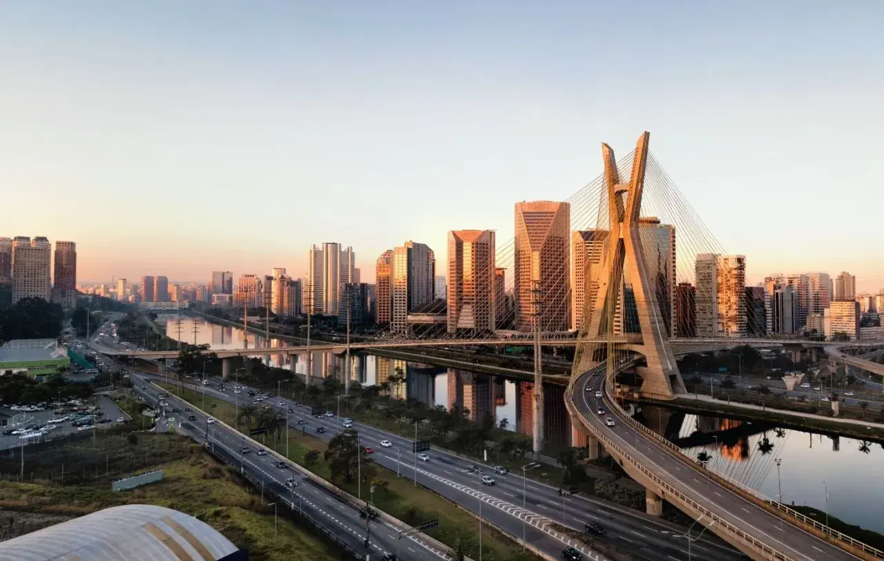 Sonnenuntergang über der Skyline von Brasilien, São Paulo. Die Ponte Estaiada, ein Wahrzeichen der Stadt, spiegelt sich im Fluss.