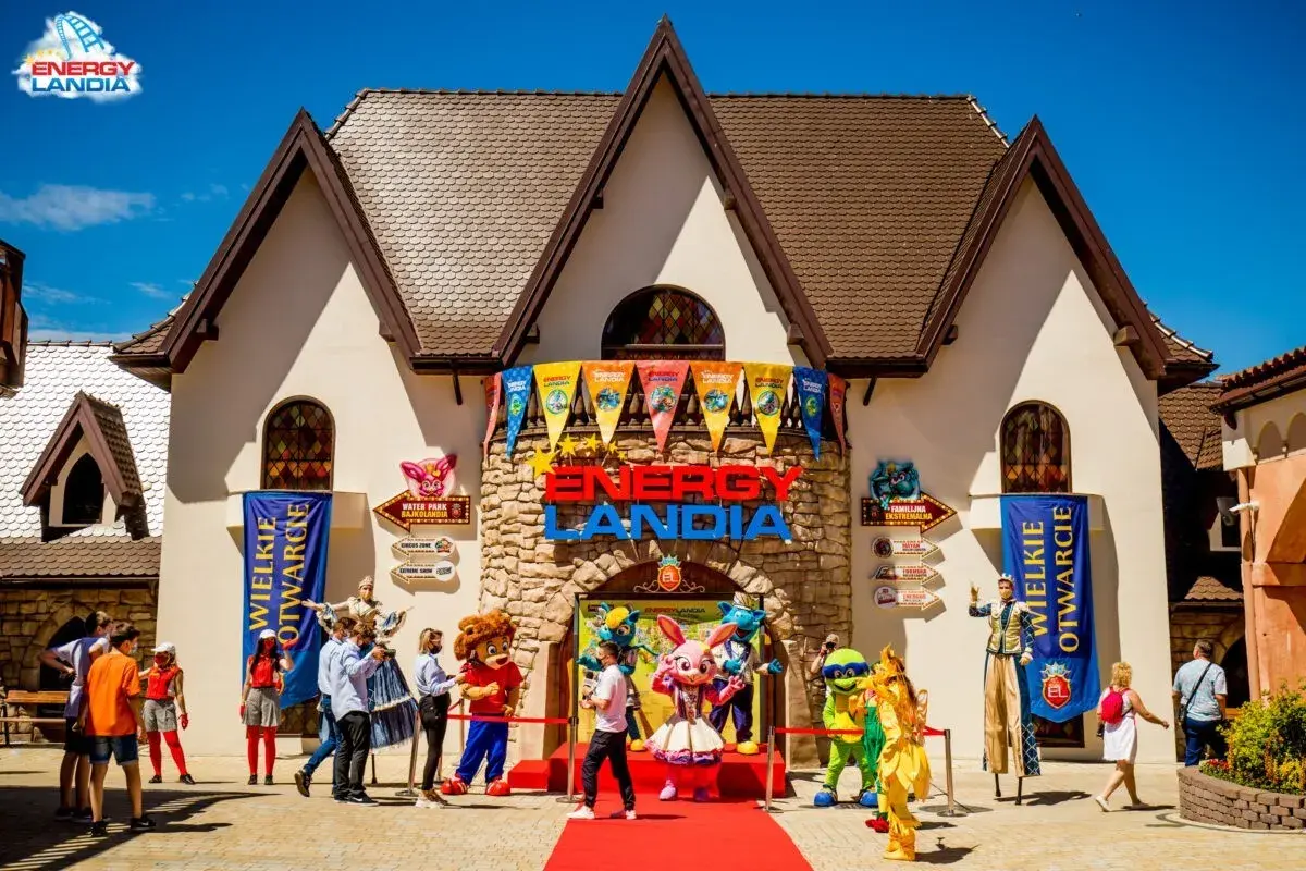 Wesołe postacie z Energylandii witać gości w Pietrzykowicach. Czerwony dywan i kolorowe flagi zapowiadają świetną zabawę.