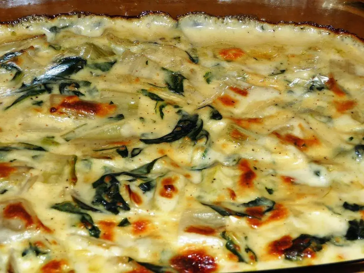 Un gratin crémeux de côte de blette, doré au four, avec des touches de vert et des bords légèrement caramélisés. Un délice réconfortant.