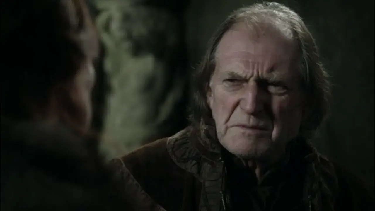 David Bradley w filmach i serialach, z charakterystycznym zmarszczonym czołem, w rozmowie z kimś.