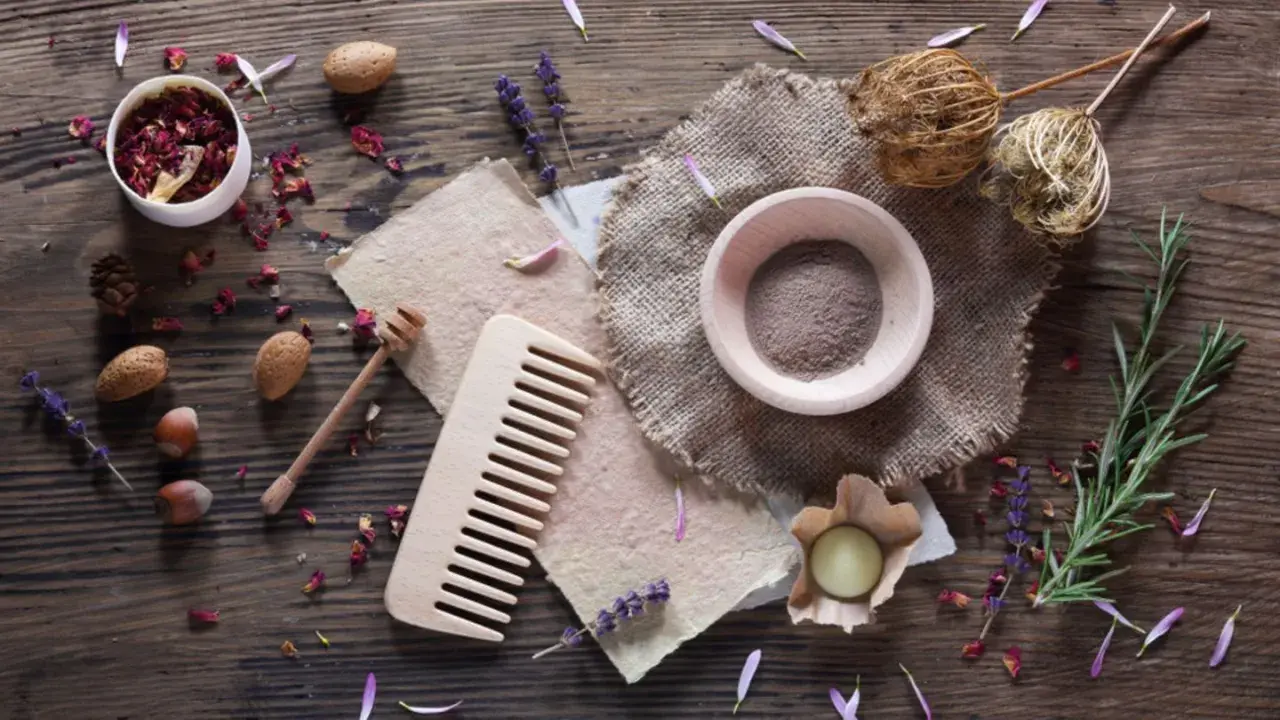 Zutaten für **shampoo selber machen**: Rosenblätter, Lavendel, Mandeln, Haselnüsse, Rosmarin, Honig, Tonerde und ein Holzkamm.