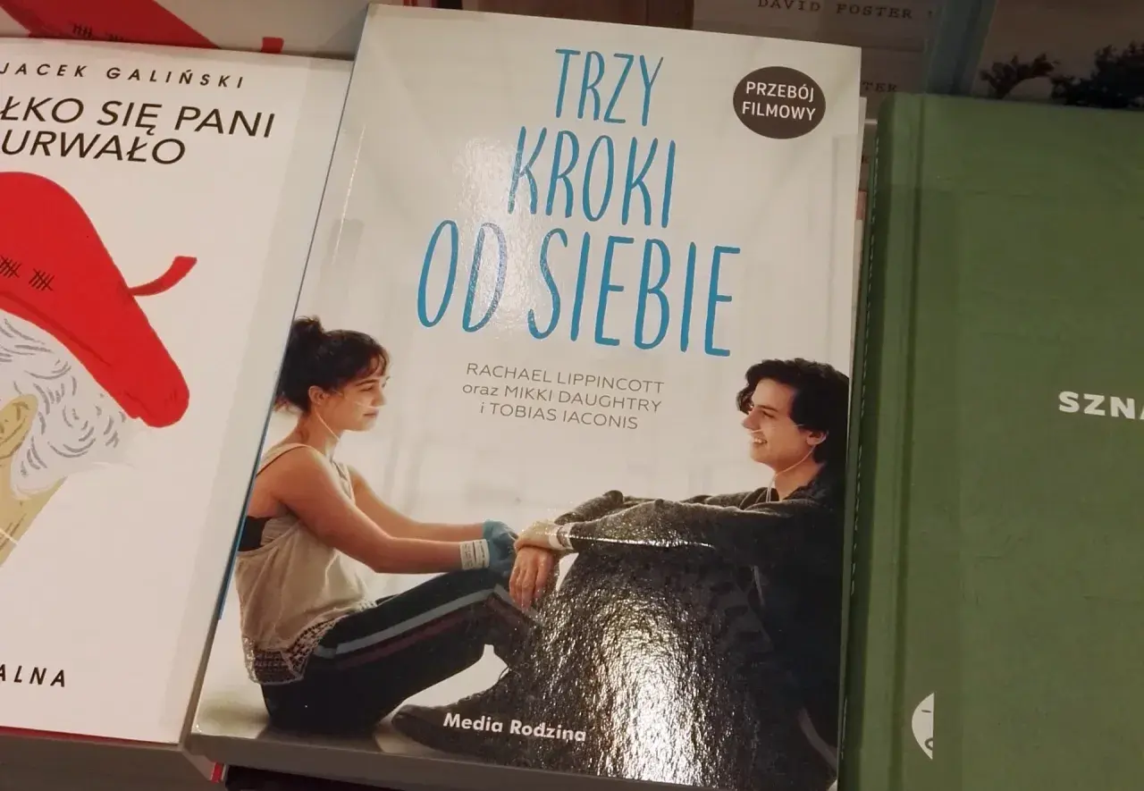 Okładka książki "Trzy kroki od siebie" z młodymi ludźmi w szpitalnych łóżkach, połączonymi rurkami.