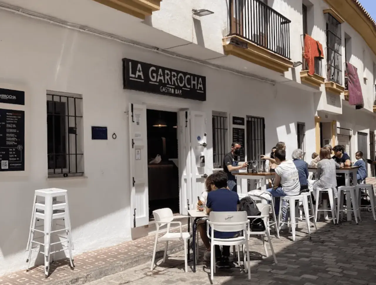 Gente disfrutando en La Garrocha Gastro Bar. Un lugar con ambiente taurino, perfecto para tapear.