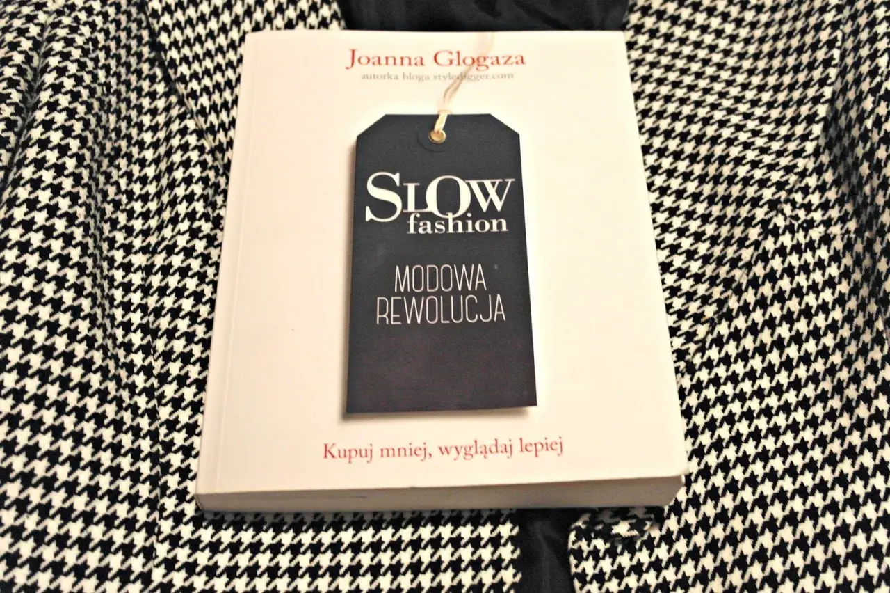 Książka "Slow fashion. Modowa rewolucja" Joanny Glogazy na tle wzorzystej tkaniny. Inspiracja dla polskich marek slow fashion.