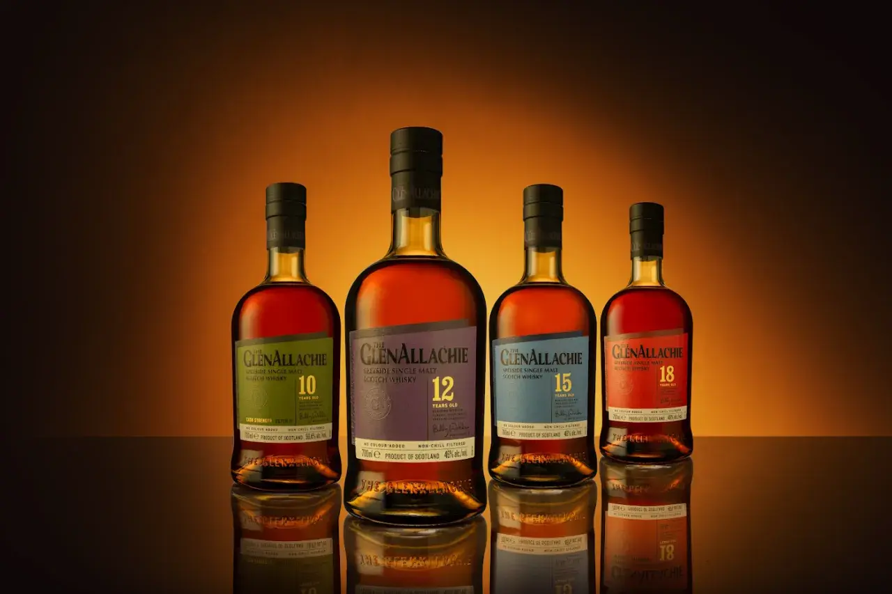 Cztery butelki whisky GlenAllachie, od 10 do 18 lat, z wyblakłymi etykietami, ukazujące skutki trzymania butelki whisky w nasłonecznionym miejscu.
