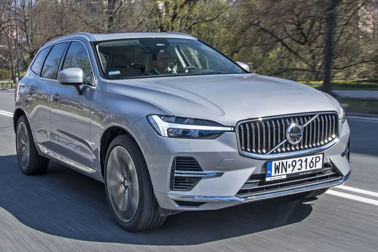 Srebrny Volvo XC60 w ruchu drogowym, widok z przodu i z boku.