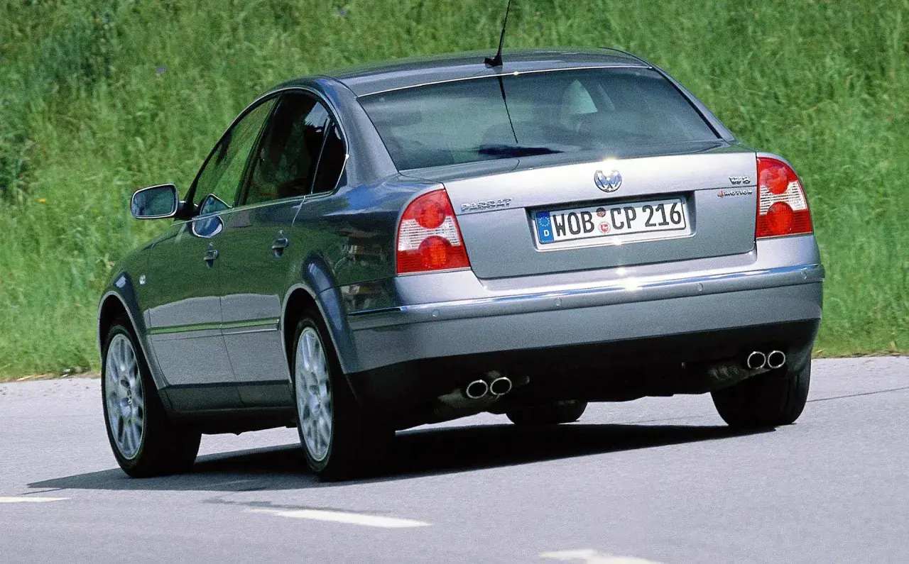 Srebrny Volkswagen Passat, wyglądający jak sleeper car, jedzie po drodze.