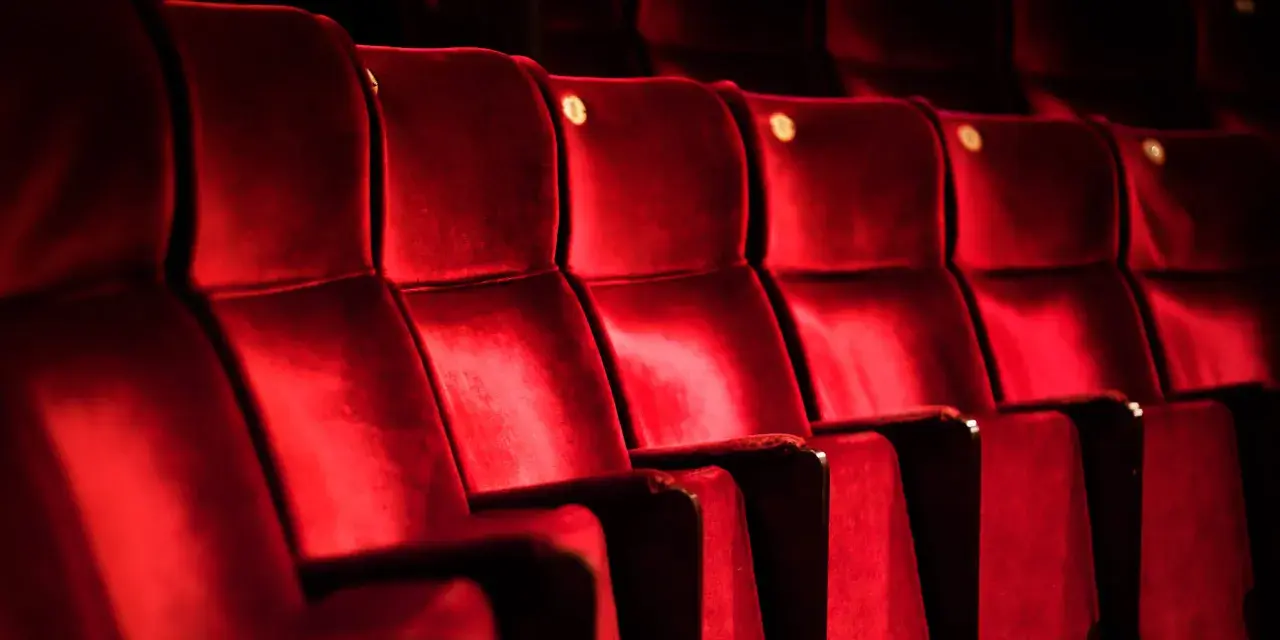 Tomma, röda sammetsstolar i en teatersalong, kanske på Södra Teatern, väntar på publiken.