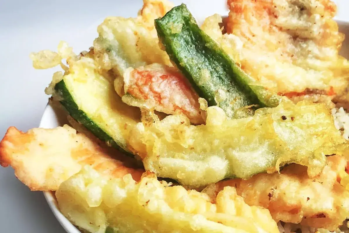 Un assortiment coloré de tempura de légumes, avec des courgettes, des haricots verts et d'autres délices croustillants.