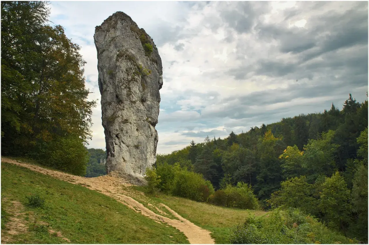 Ojcowski Park Narodowy: majestatyczna Maczuga Herkulesa góruje nad zielonymi wzgórzami i lasem.