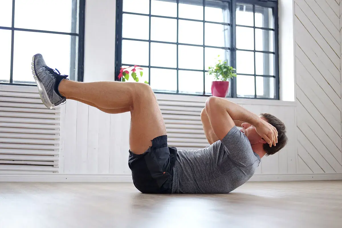 Hombre haciendo abdominales, parte de una rutina de ejercicios para bajar barriga.