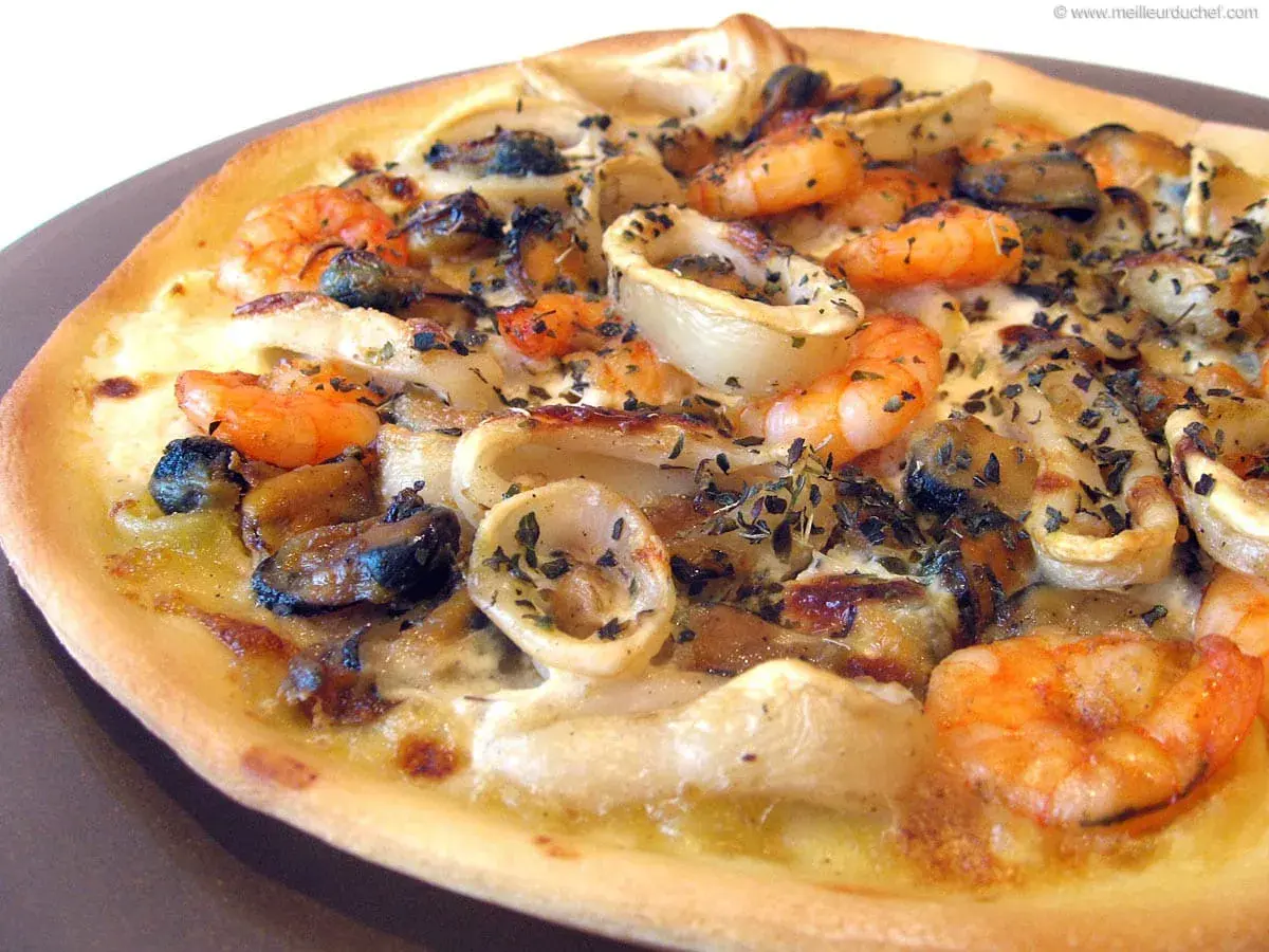 Une délicieuse pizza fruit de mer, garnie de crevettes, moules et calamars, saupoudrée d'herbes.