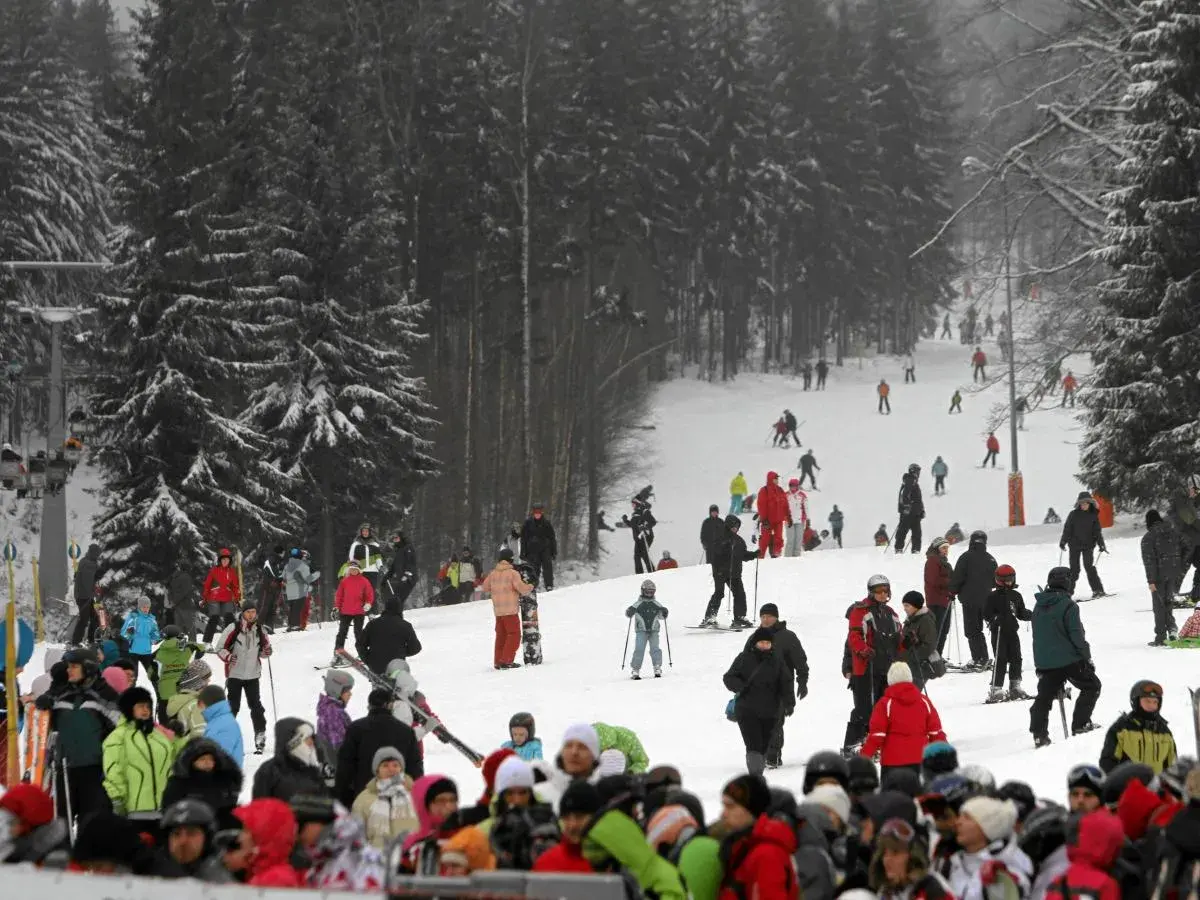 Tłumy narciarzy i snowboardzistów na stoku, przygotowujących się do szusowania. Wszyscy cieszą się zimową atmosferą, jakby to były ich wymarzone ferie 2027.