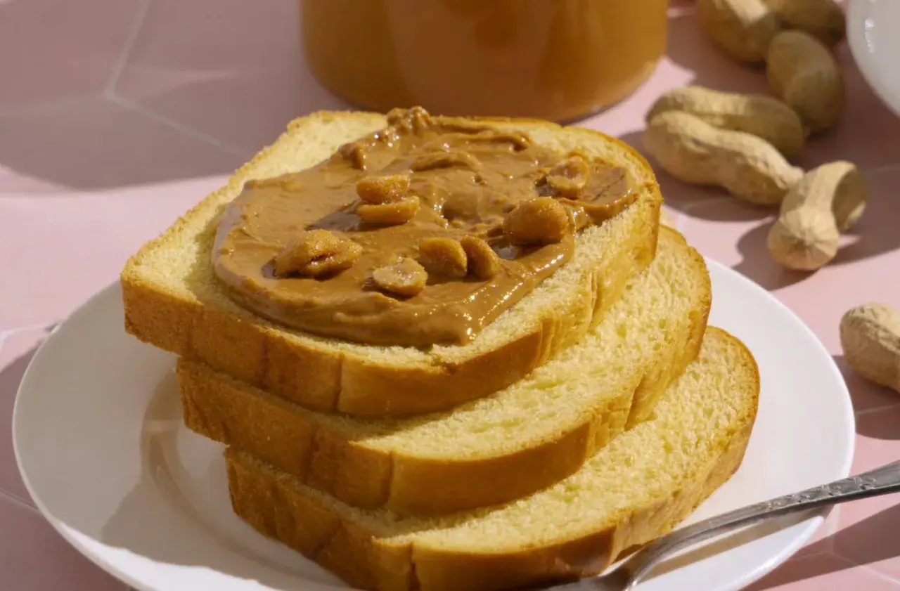 Stos kanapek z masłem orzechowym, z orzeszkami na wierzchu. Czy pies może masło orzechowe? To pytanie nurtuje wielu właścicieli czworonogów.