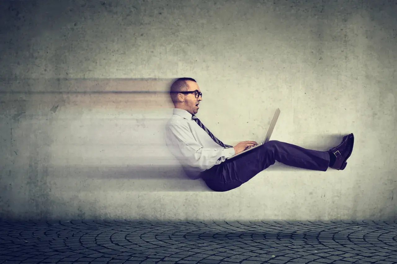 Uomo d'affari con laptop, in movimento rapido, sembra che stia facendo fast tracking verso il successo.