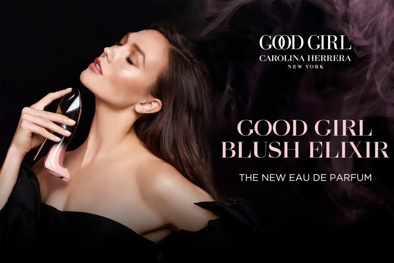 Kobieta zmysłowo wącha perfumy Carolina Herrera Good Girl Blush Elixir w różowym flakonie w kształcie szpilki.