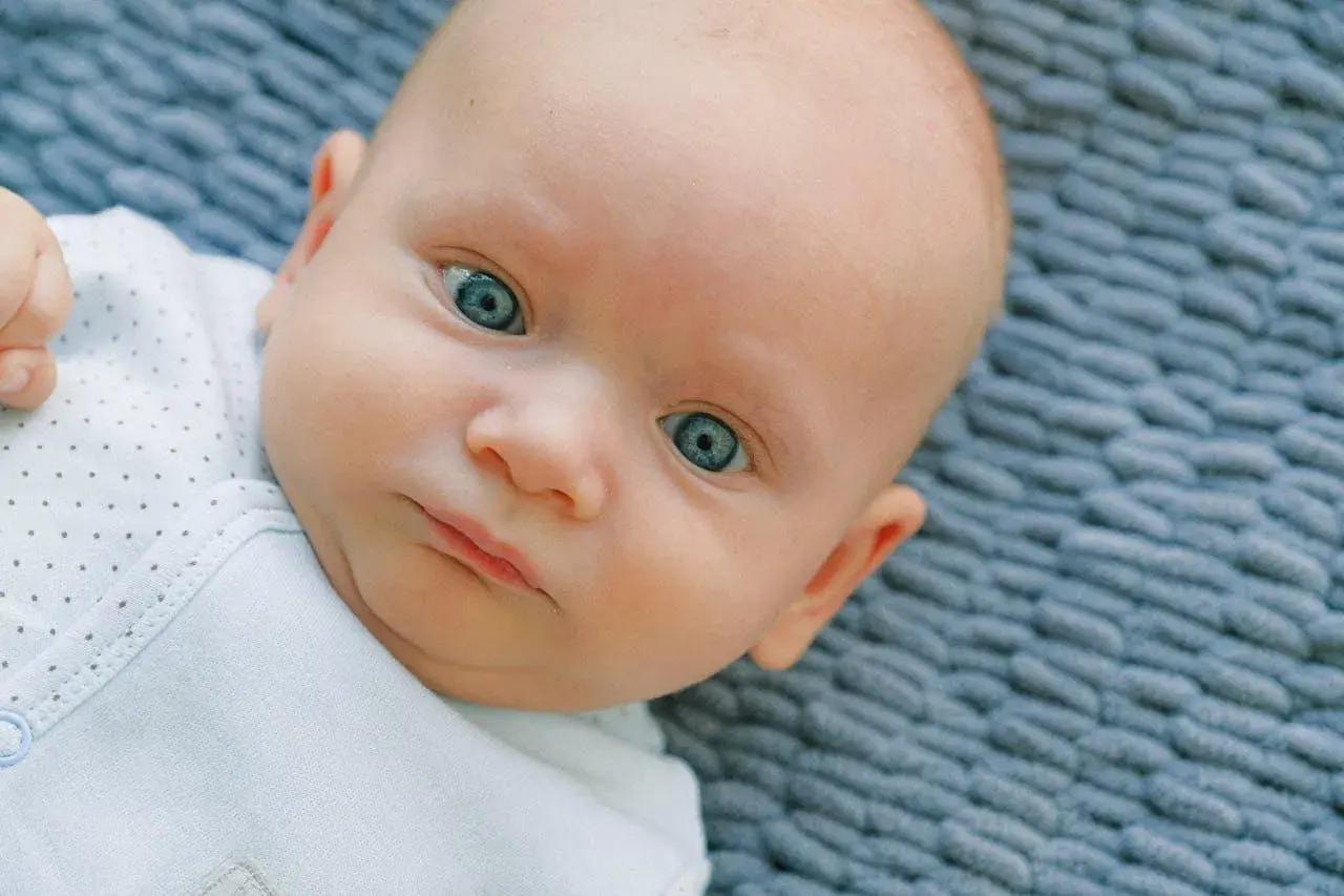 Occhi di un neonato di un blu intenso, quasi neon, che catturano lo sguardo.