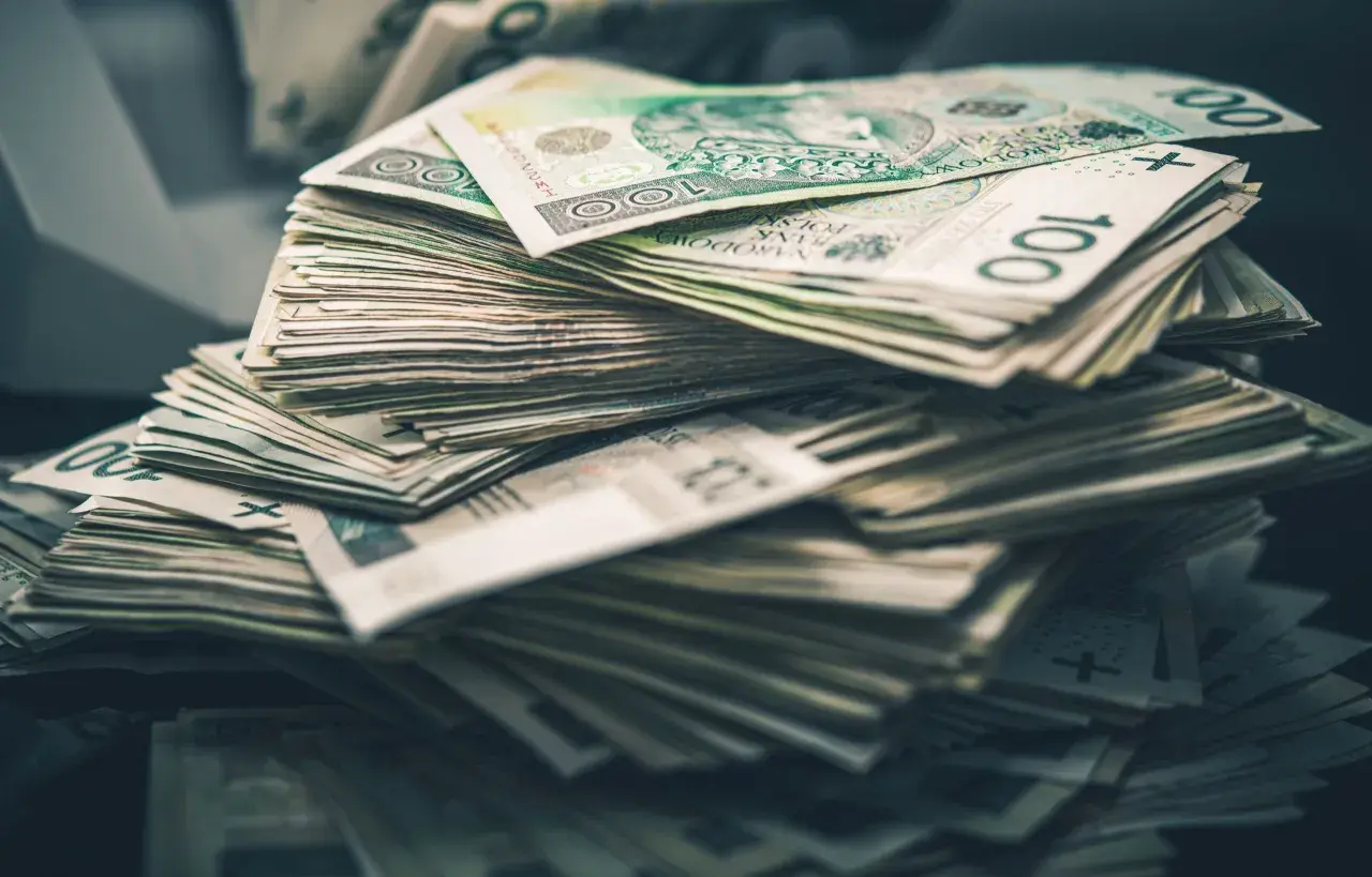 Góra stosu polskich banknotów 100 zł. Taka ilość pieniędzy to dla wielu osób symbol zadośćuczynienia i spełnienia marzeń.
