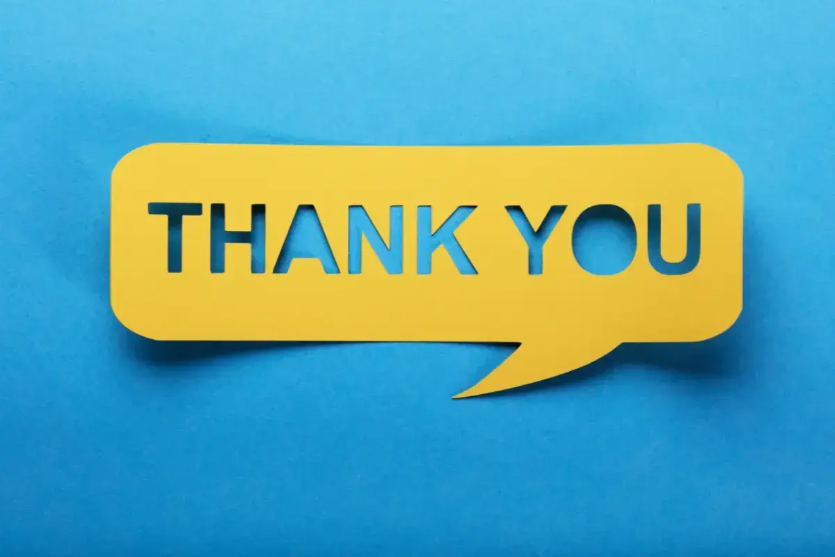 Un fumetto giallo ritagliato con la scritta "THANK YOU" su sfondo blu. Un modo per dire "prego" o "di niente" quando qualcuno ti ringrazia.