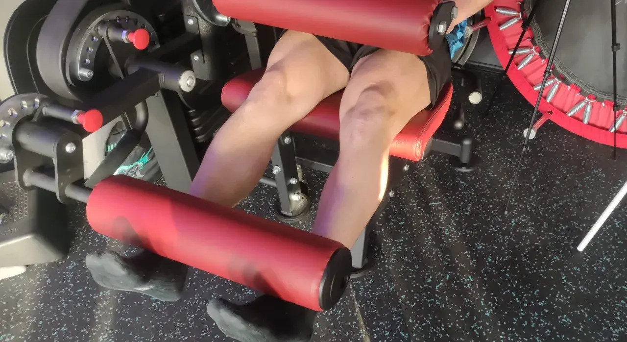 Persona esegue esercizi per rinforzare le ginocchia su una macchina da palestra.