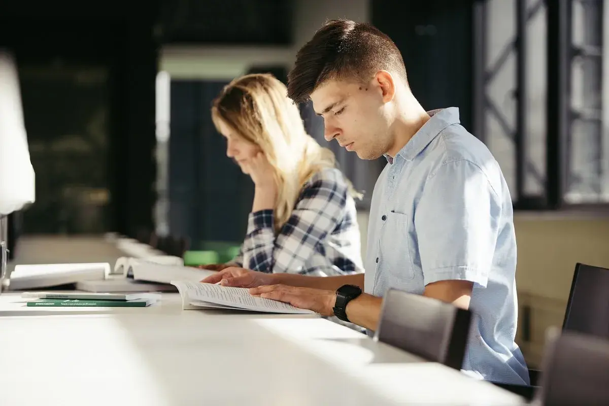 Estudiantes concentrados estudiando para entender como funcionan las oposiciones de maestro.