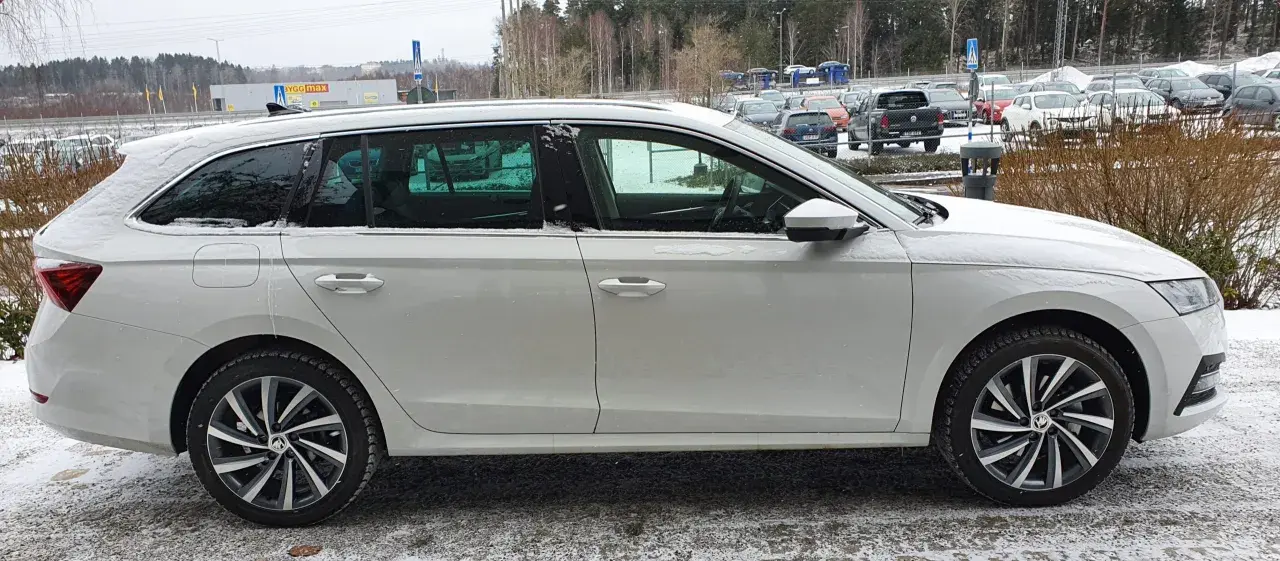 Vit Skoda Octavia laddhybrid parkerad i snö. Bilen har mörka fönster och snygga fälgar.
