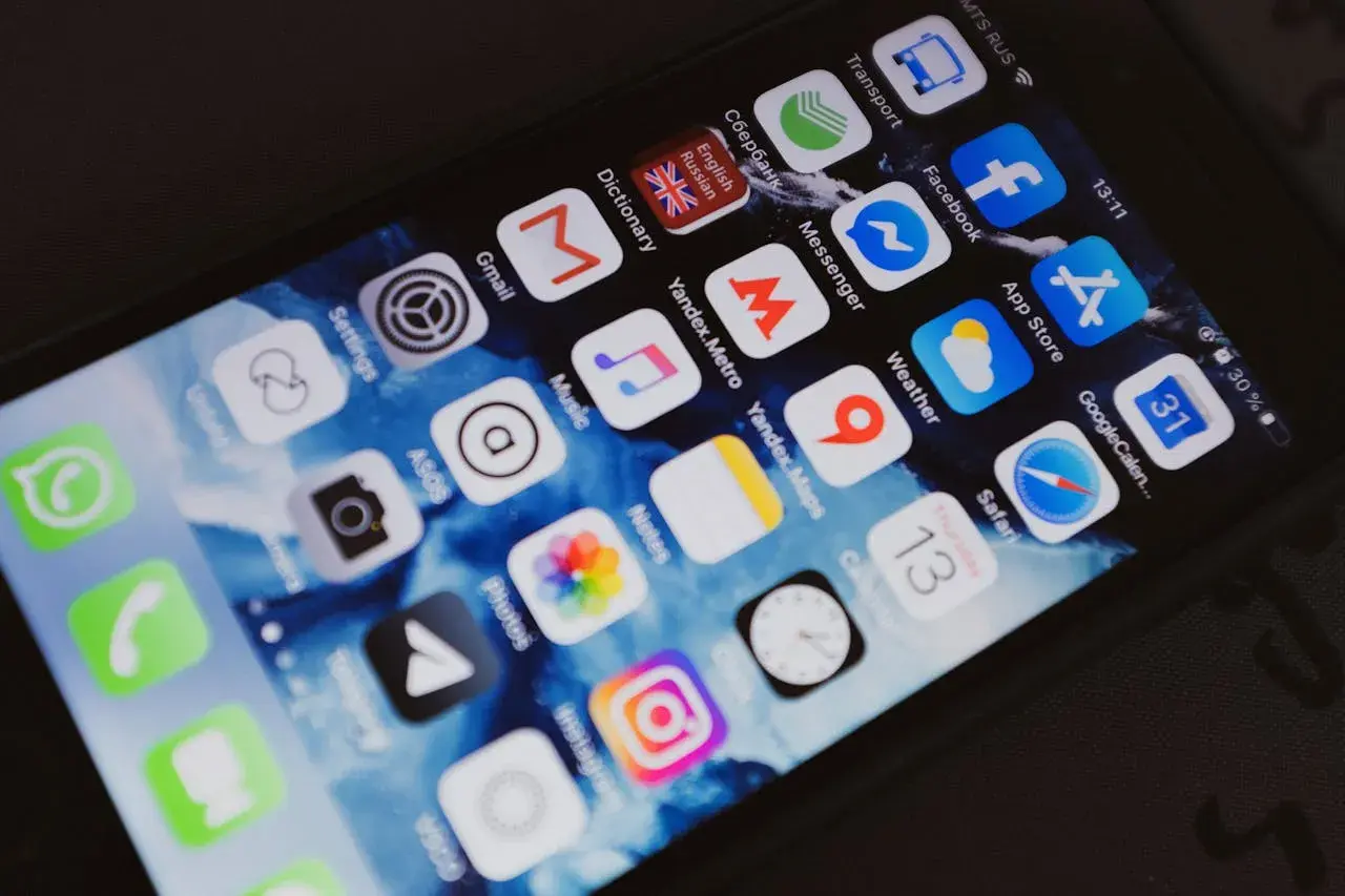 Ekran smartfona z ikonami aplikacji, w tym Facebook. Chcesz wiedzieć, jak sprawdzić czyjś numer telefonu na Facebooku?