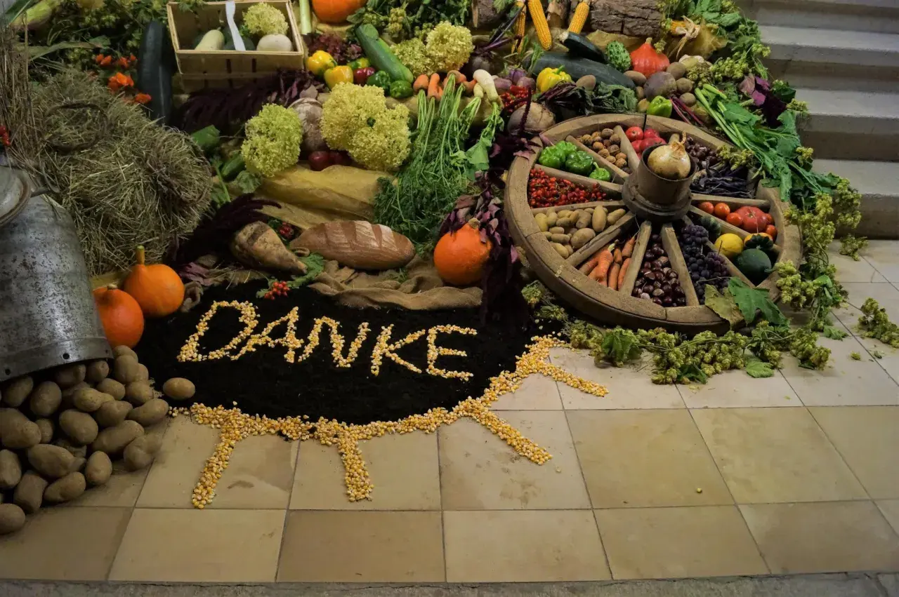 Ein liebevoll gestalteter Erntedankaltar mit Gemüse, Früchten, Brot und dem Wort "Danke" aus Mais.