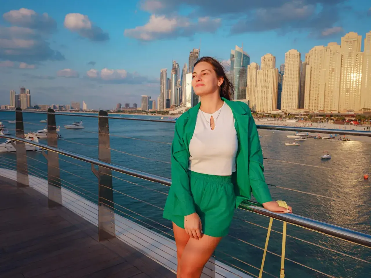 Junge Frau in grüner Kleidung genießt die Aussicht auf die Skyline von Dubai. Keine Sorge wegen Zika-Virus.