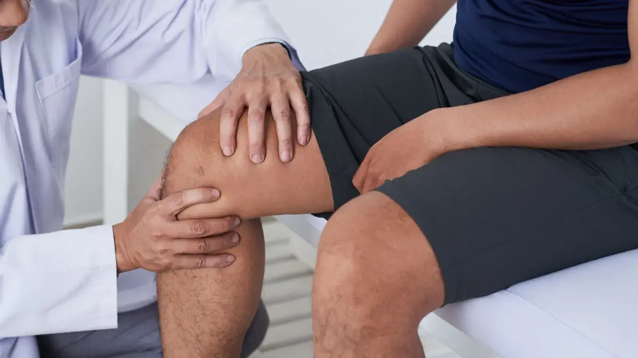 Arzt untersucht Knie eines Patienten, um pes anserine bursitis zu diagnostizieren.