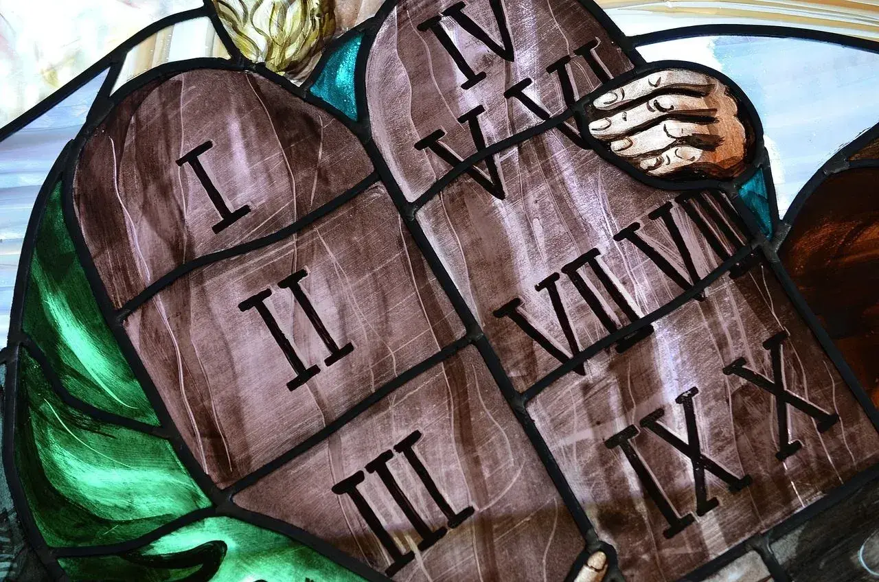 Fragment witrażu przedstawiający kamienne tablice z rzymskimi cyframi od I do X.