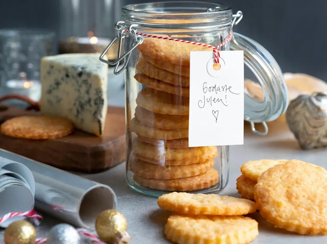 En burk med staplade parmesan kex, en bit blåmögelost och juldekorationer. Perfekt för julens fika!