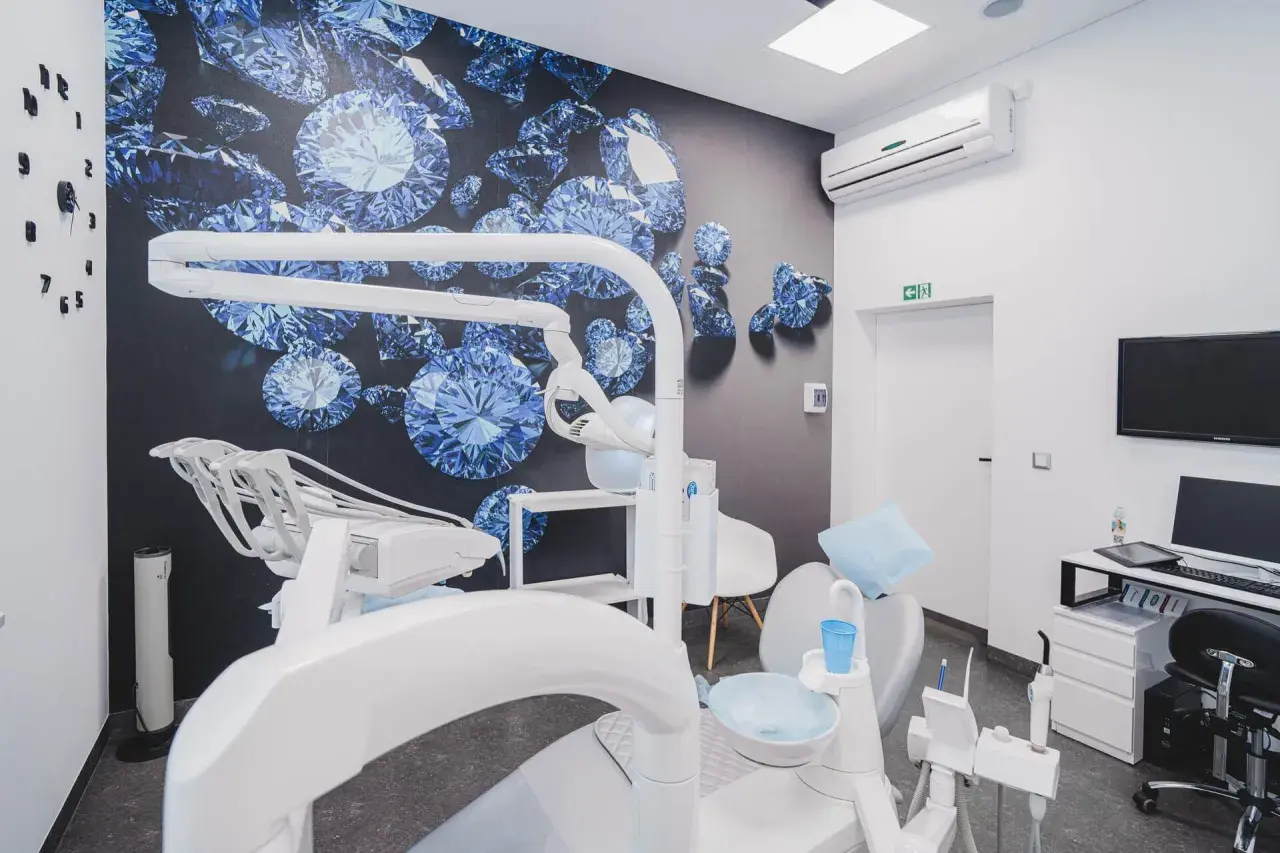 Nowoczesny gabinet stomatologiczny z fotelem dentystycznym i tapetą z niebieskimi diamentami.